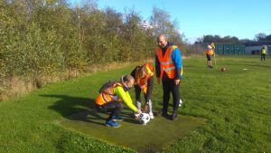 Three people playing foot golf