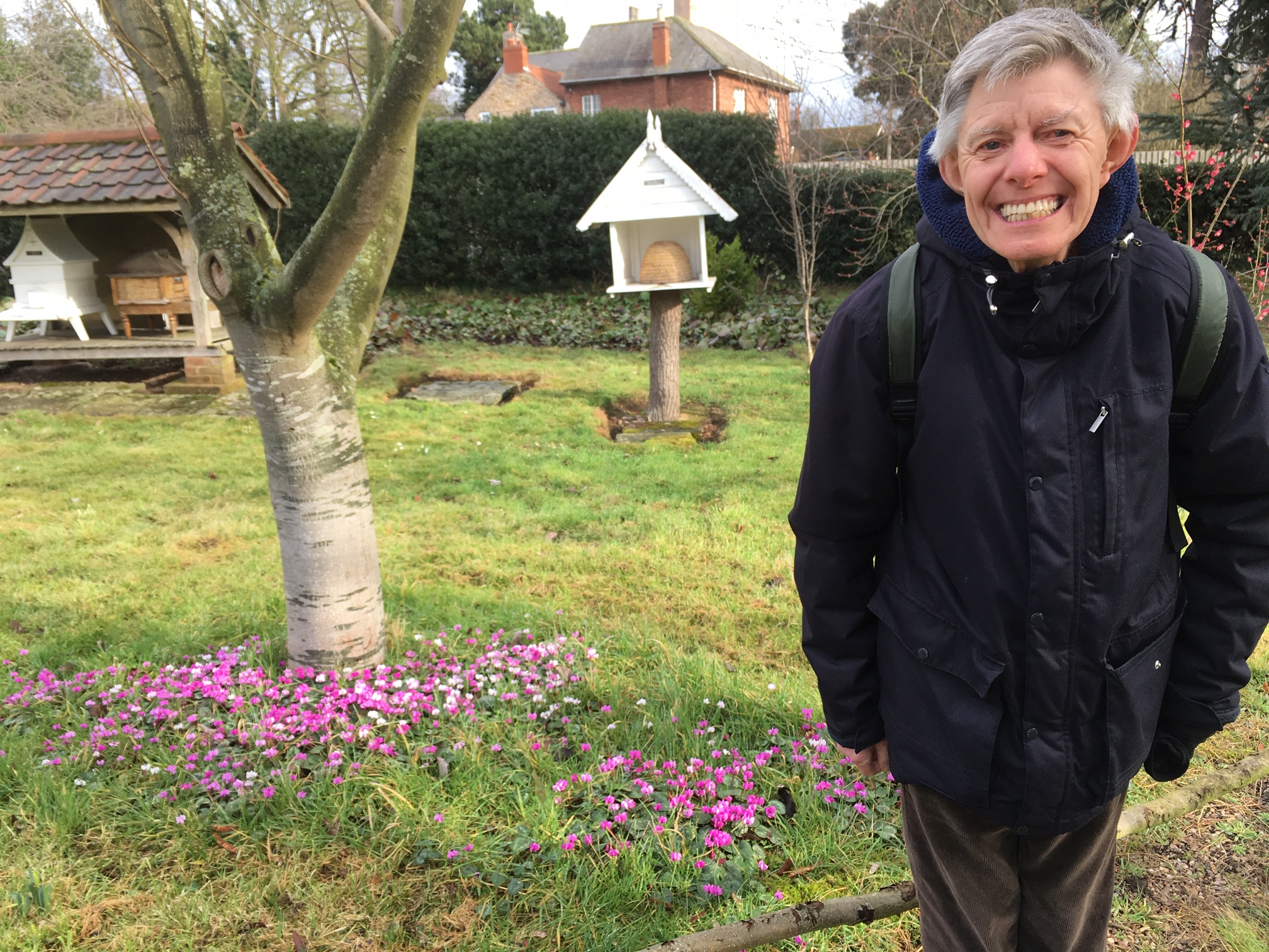 A man standing in a garden with a big smile