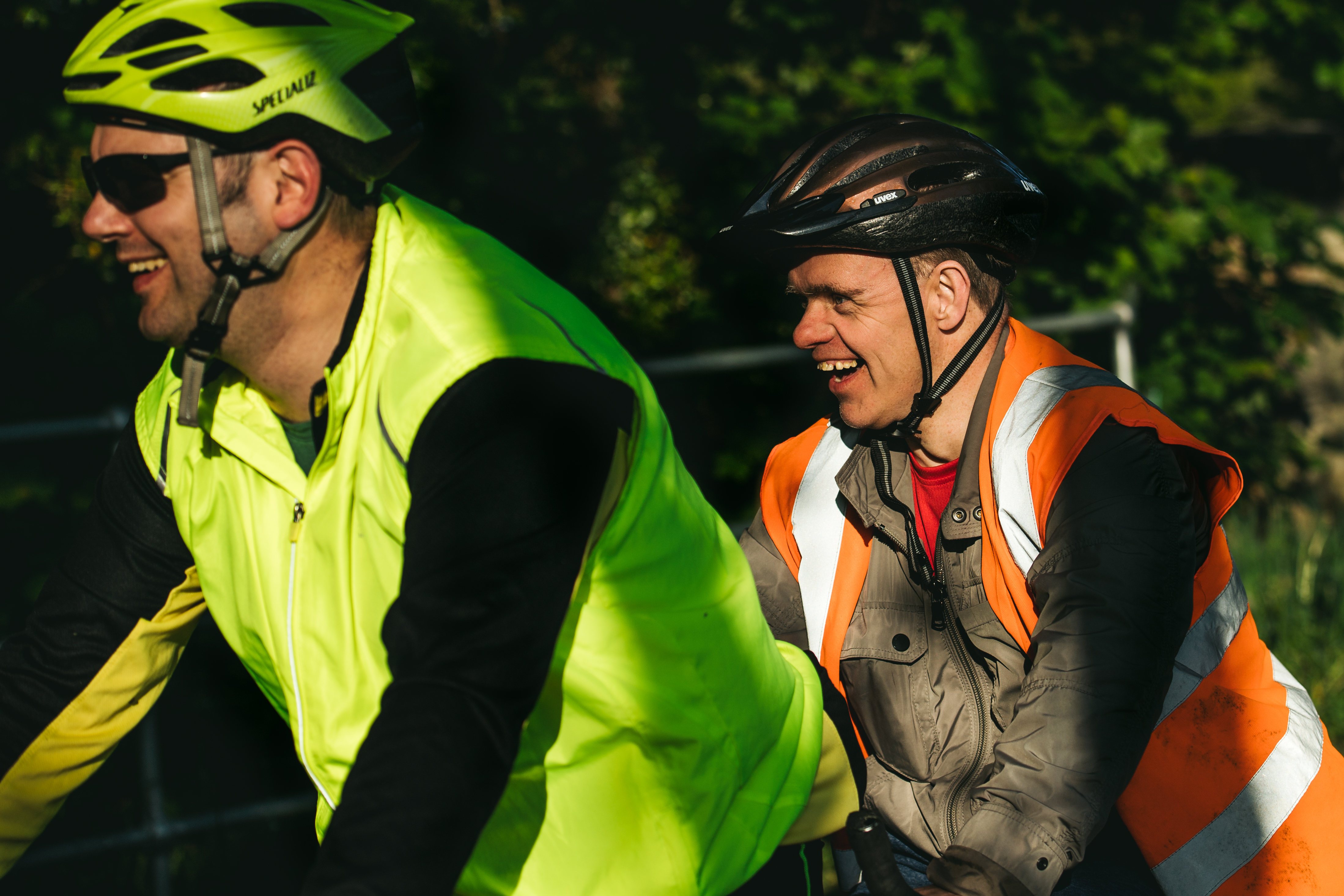 Two people smiling on a tandem.