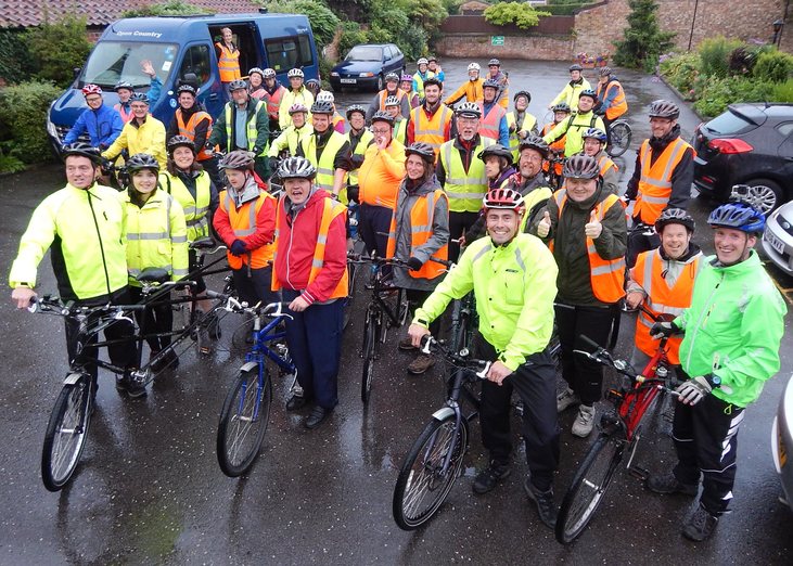 A large group of tandem cyclists in high-viz