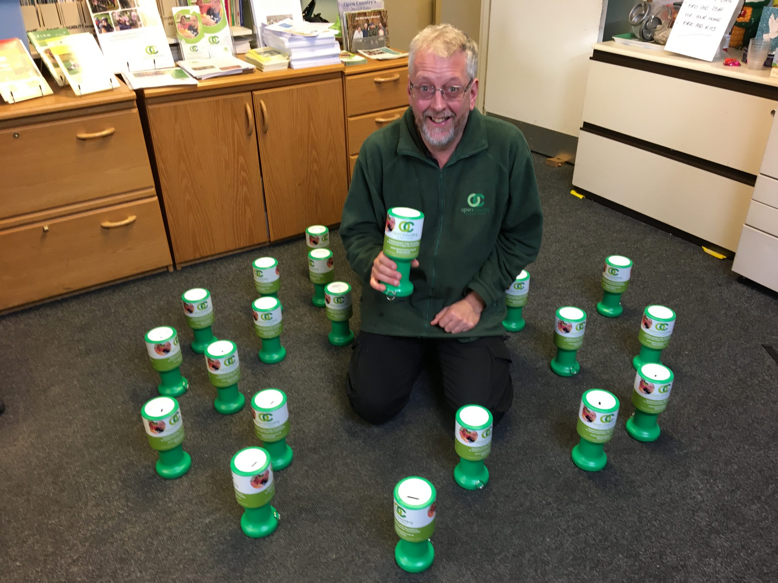 A man with lots of charity collection tins
