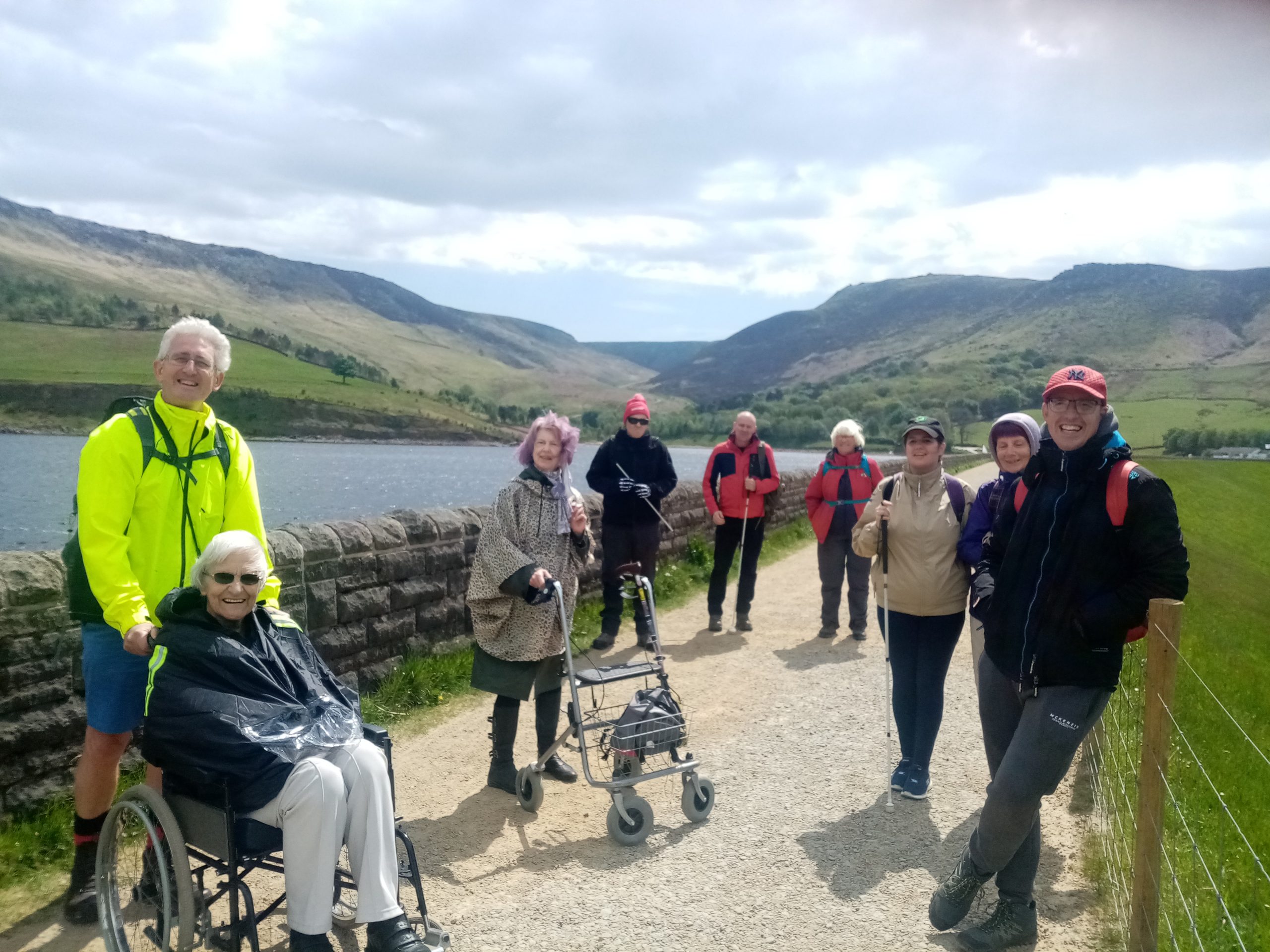 A group of walkers and wheelchair users by a reservoir