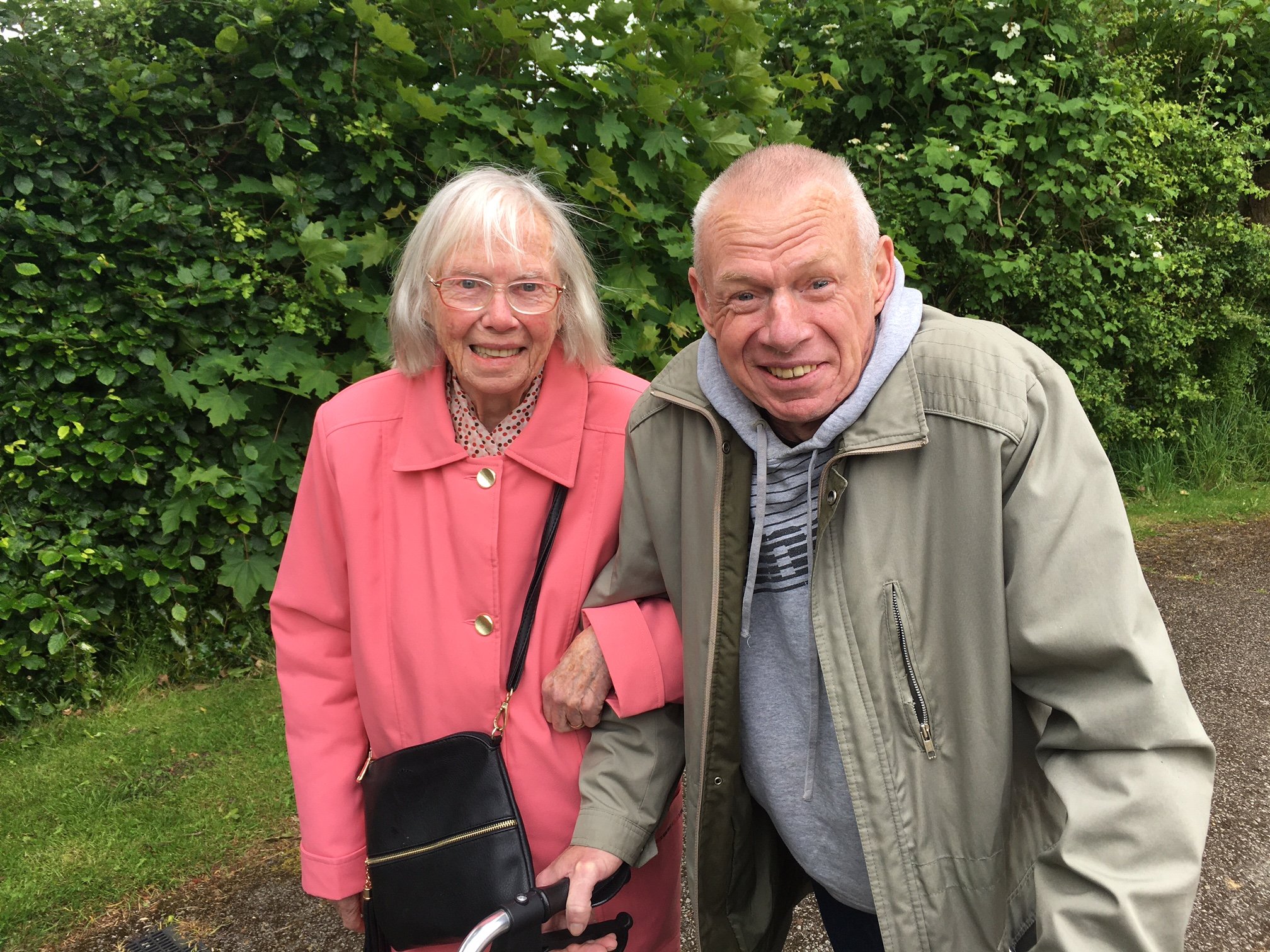 An elderly woman standing with a man outside