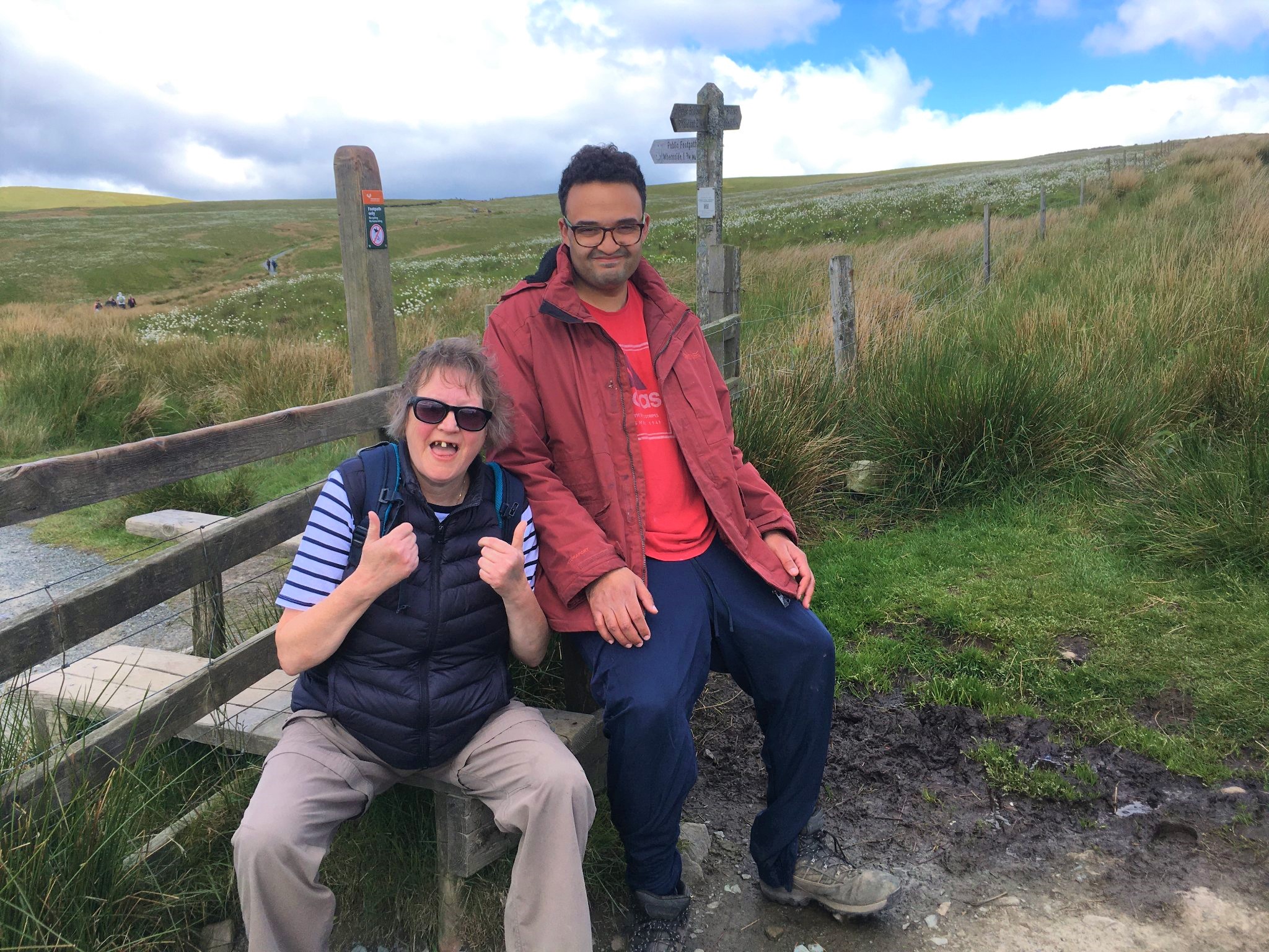 A man and woman with countryside behind them