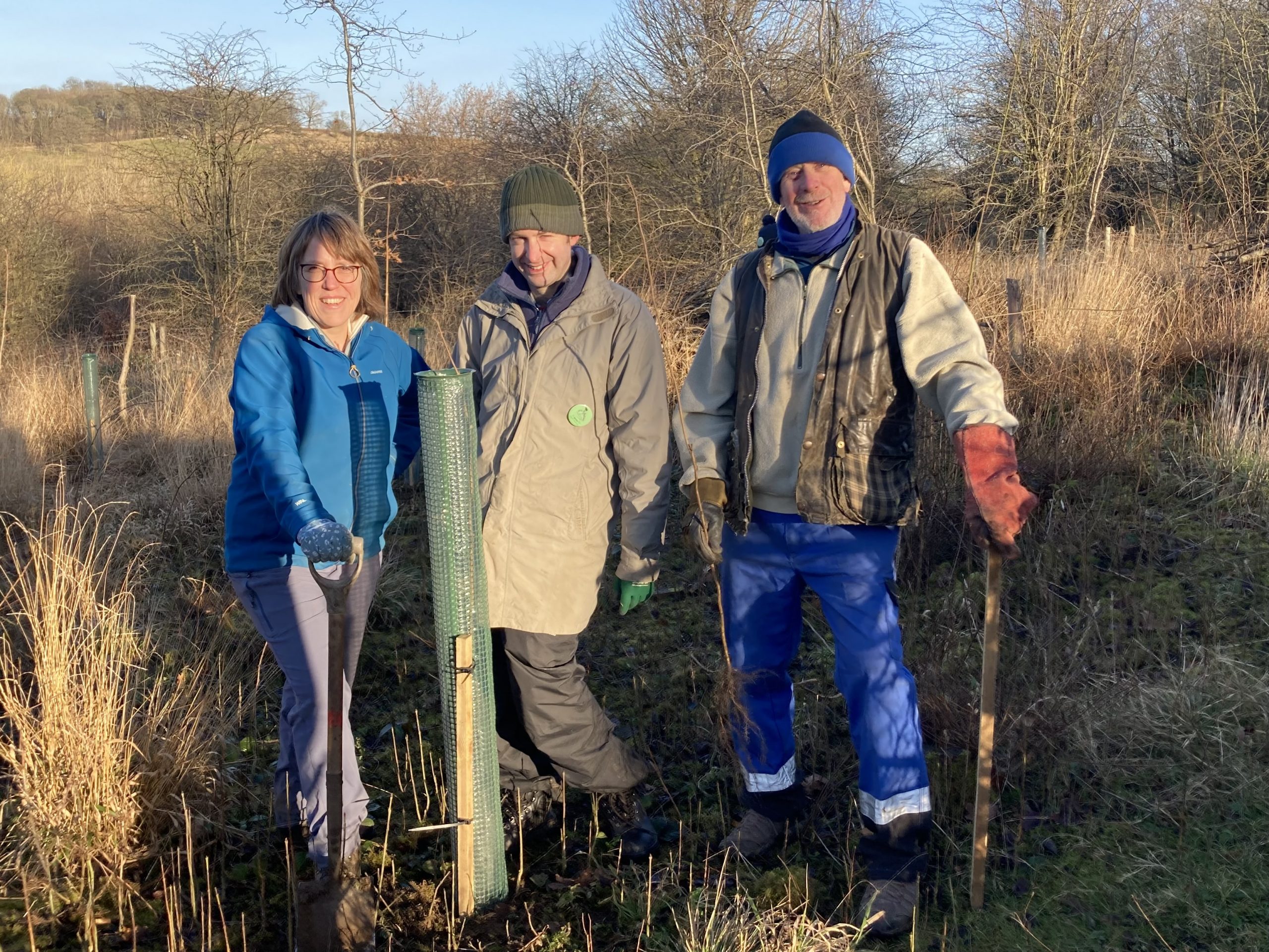 Three smiling volunteers on a nature reserve
