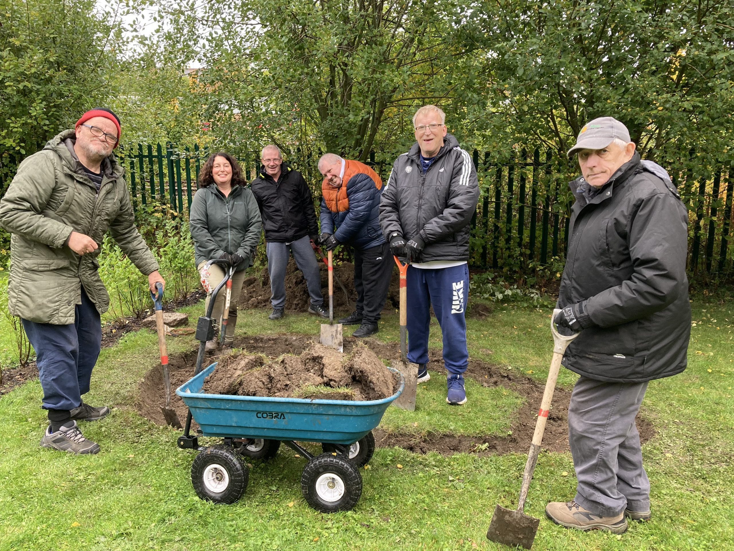 A group of people digging a pond