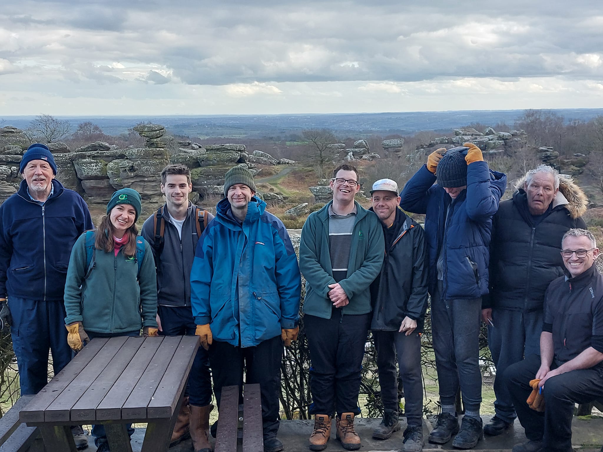 A group of people smiling with the countryside behind them