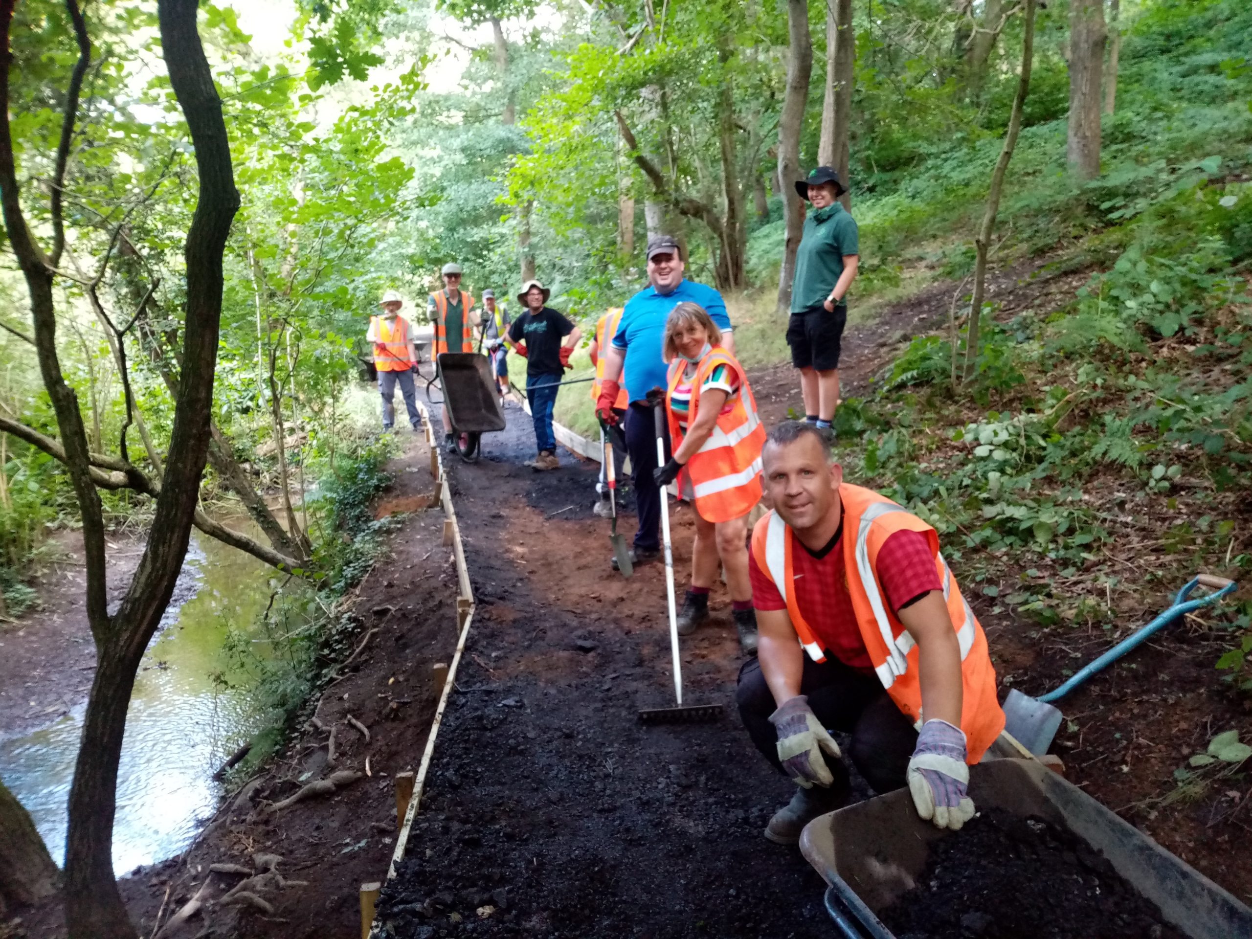 A group of people standing on a path with tools