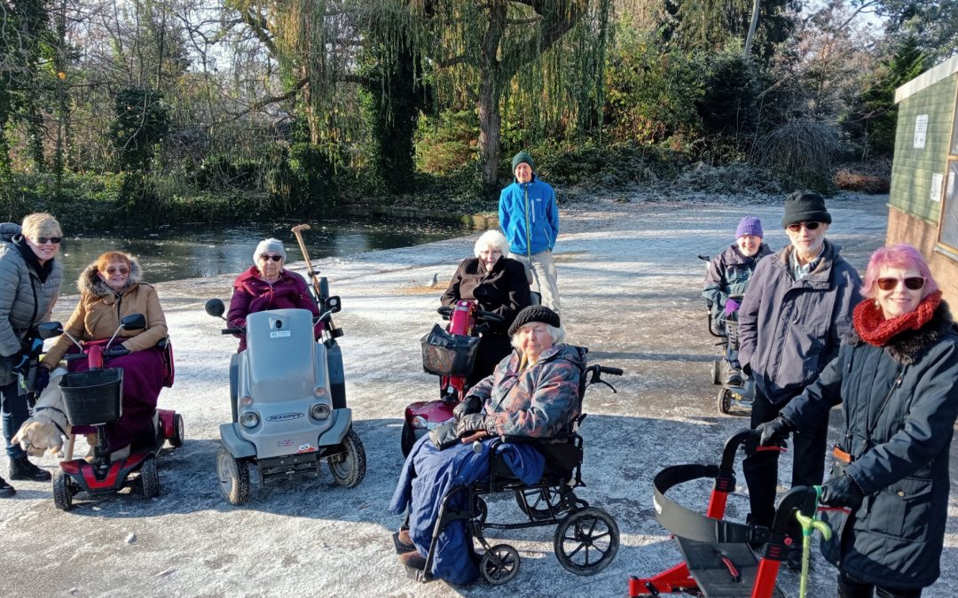 People on mobility scooters and wheelchairs on a frosty day in a park