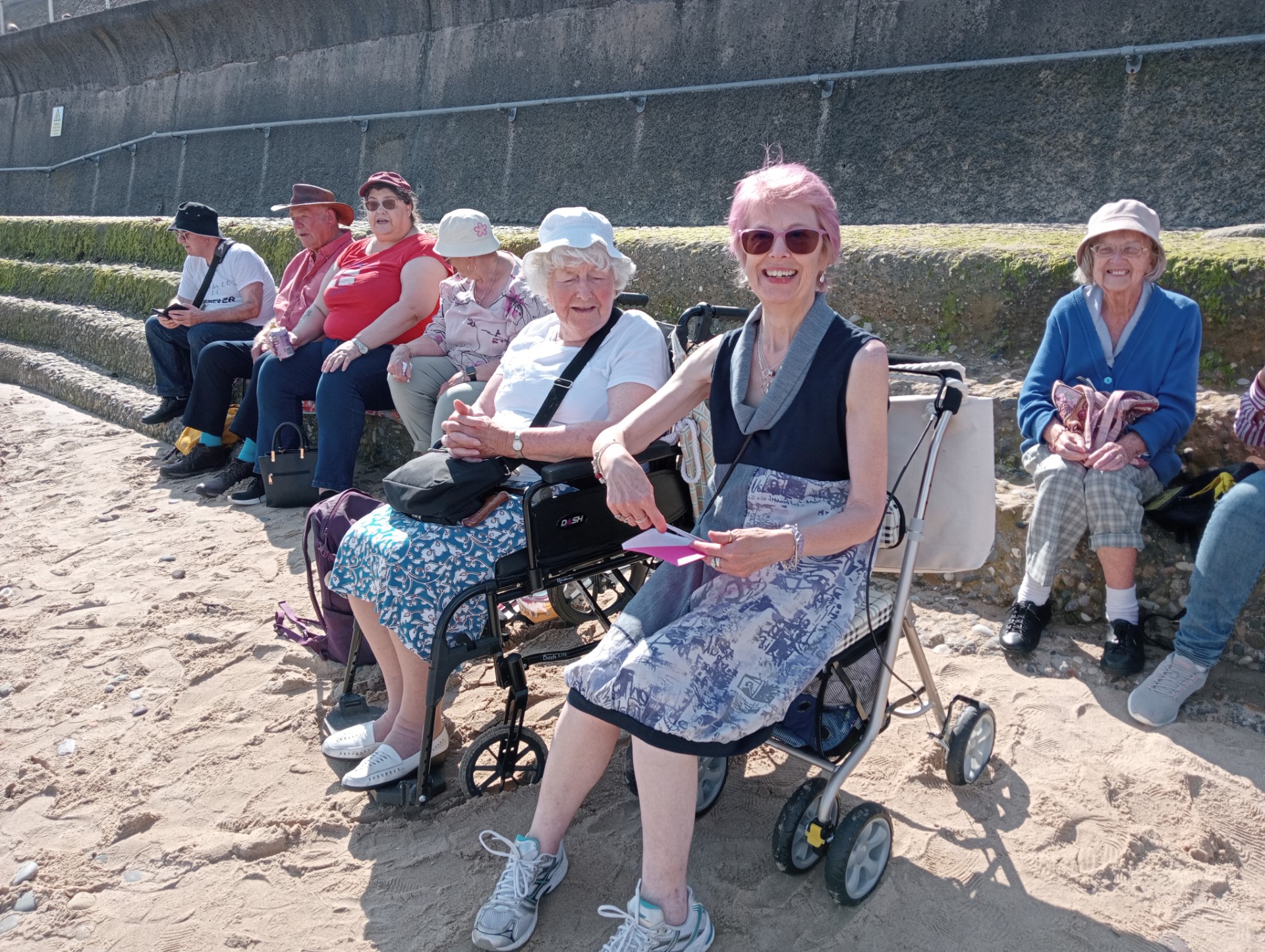 A group of people sitting on the beach