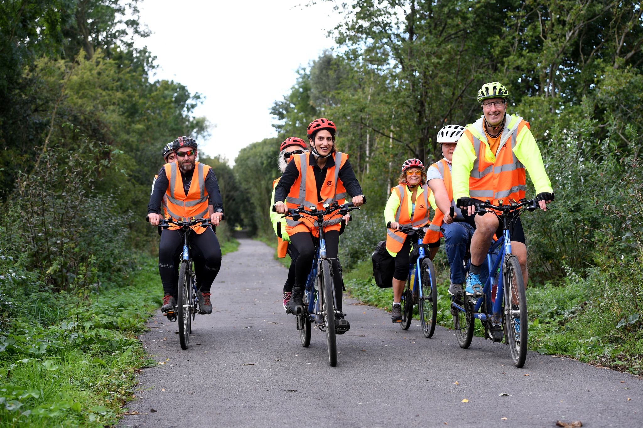 A group of riders on tandem bikes on a cycle path