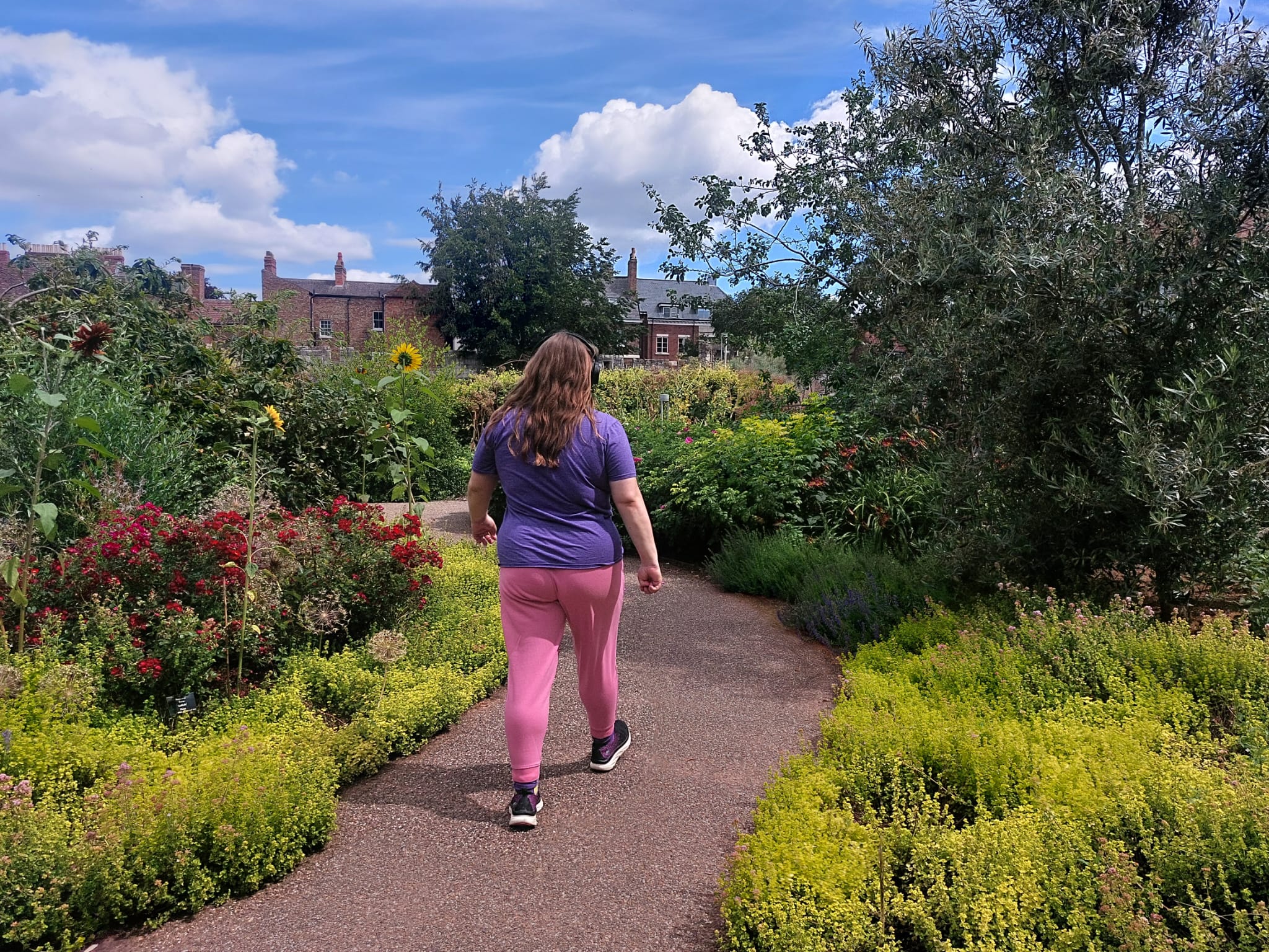 A woman walking down a garden path
