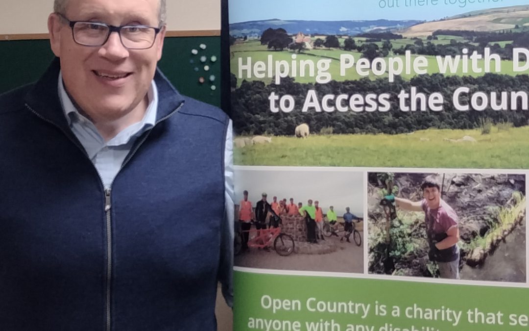 Jonty Warneken by an Open Country banner