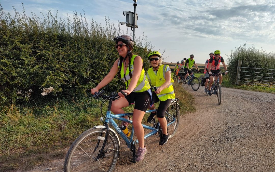 Two women on a tandem on a country lane