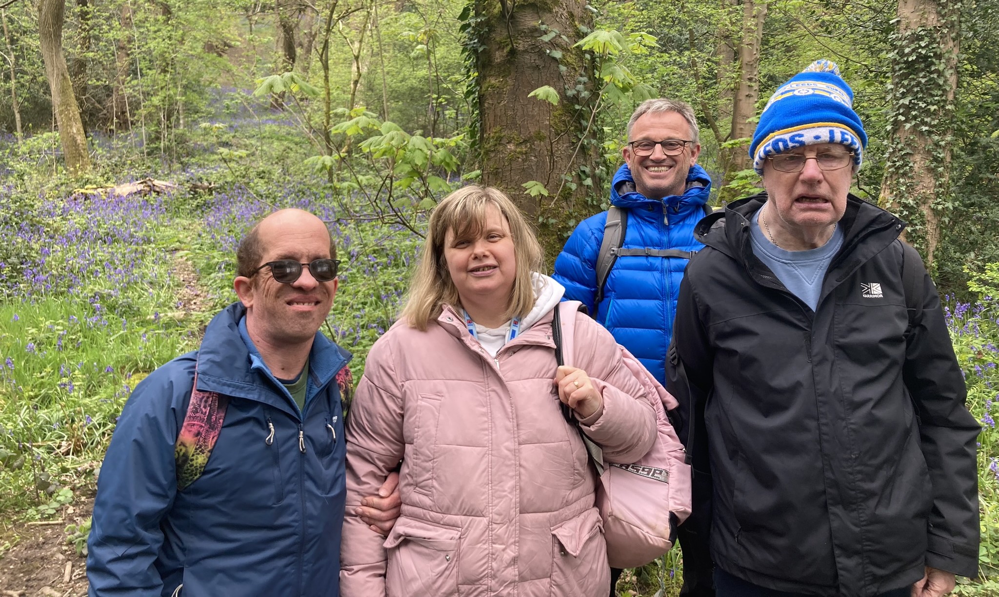 Four people standing in woodland