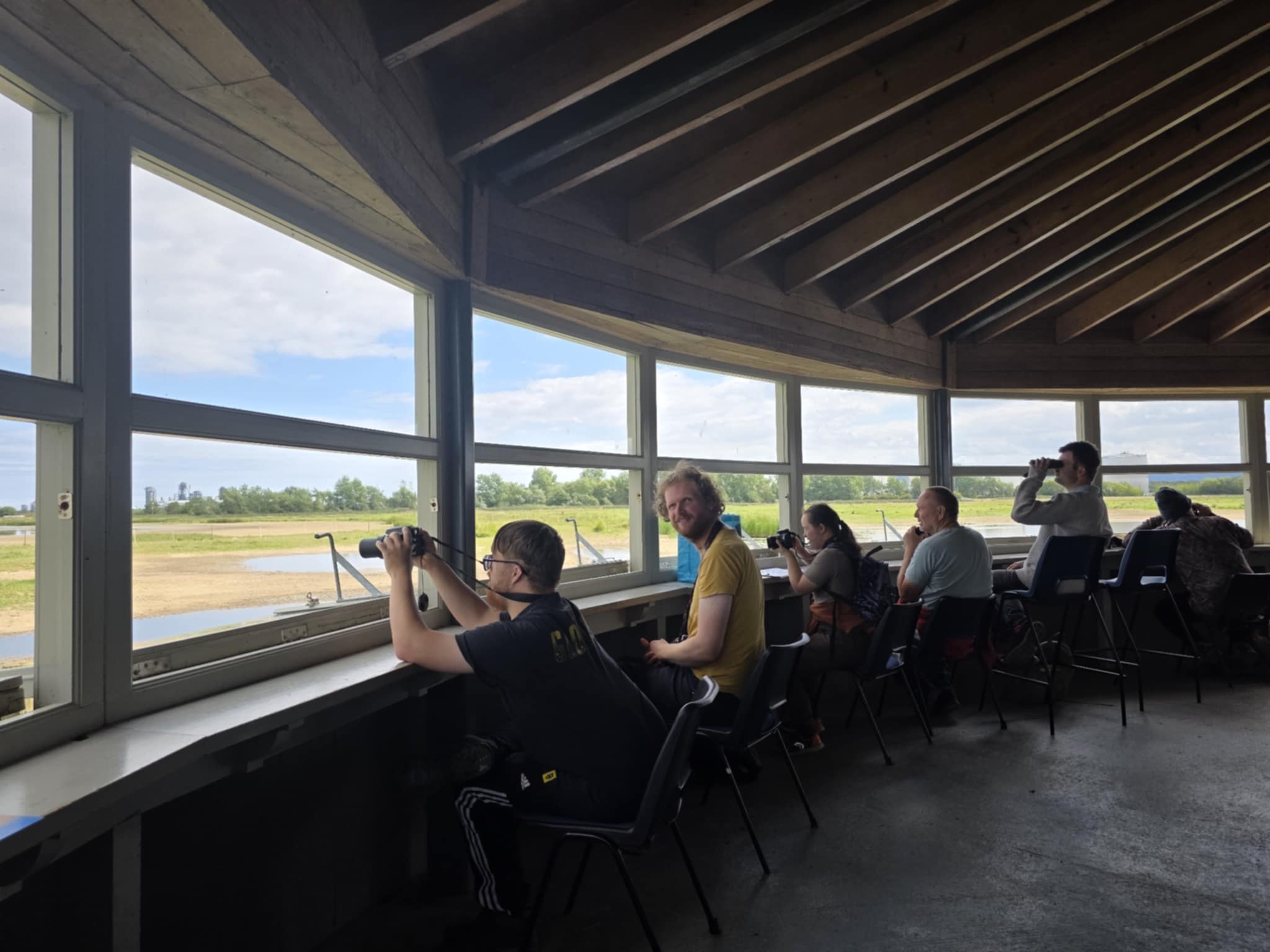 A group of people in a hide birdwatching